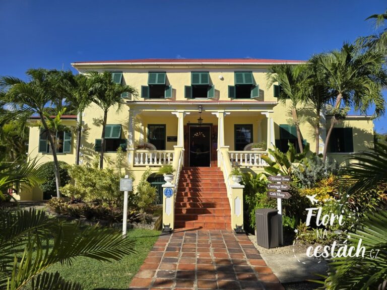 Průčelí historického domu Sunbury Plantation House na Barbadosu s tropickou zahradou.