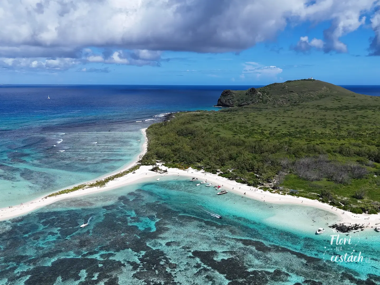 Letecký záběr z dronu na Flat Island na Mauriciu s bílou písečnou pláží, loděmi a tyrkysovým korálovým útesem